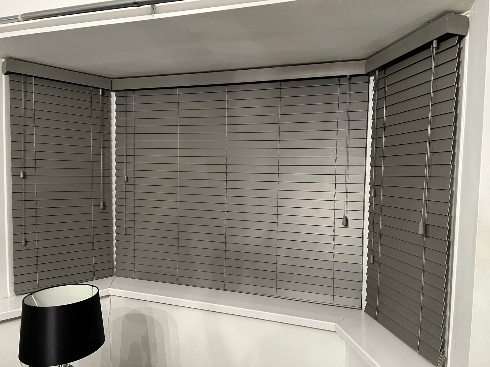 White faux wood Venetian blinds in a bright room