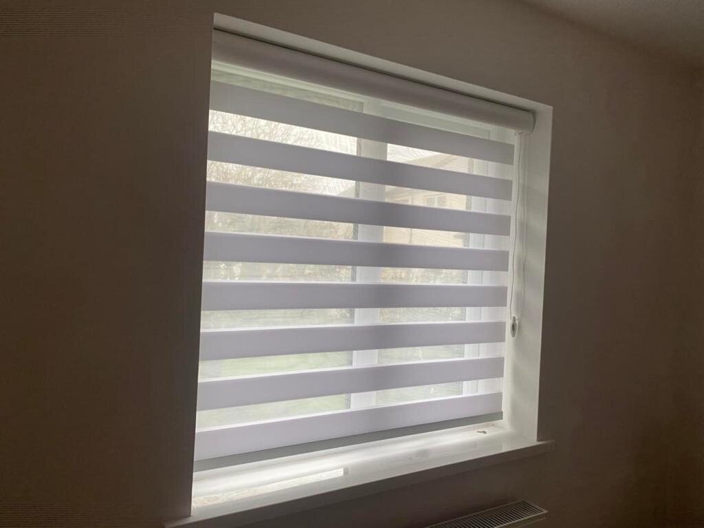 Striped night and day blinds fitted in a modern room
