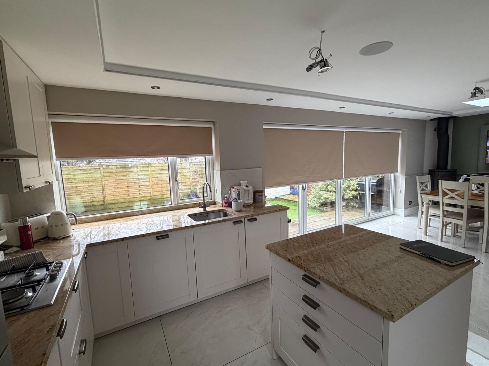 Neutral roller blinds fitted in a bright modern kitchen